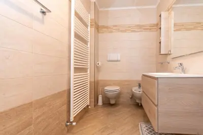 a bathroom with a toilet and a sink at Appartamento Monzoni in Pozza di Fassa