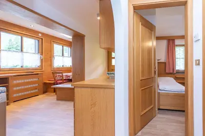 a room with a kitchen and a bedroom at Appartamento Vajolet in Pozza di Fassa