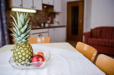 a pineapple on a table with a bowl of fruit at Apartment Suliva in Santa Cristina in Val Gardena
