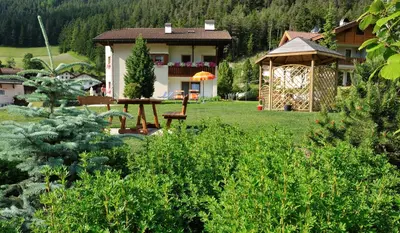a house with a table and a gazebo in a yard at Apartment Suliva in Santa Cristina in Val Gardena