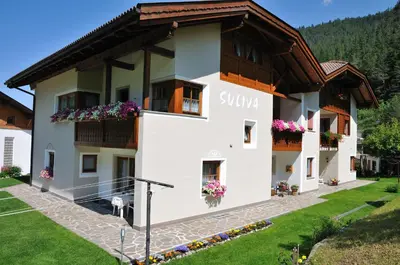 a large white building with flowers on the windows at Apartment Suliva in Santa Cristina in Val Gardena
