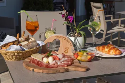 a table with a tray of food and bread and drinks at Gasthof Tuscherhof in Braies