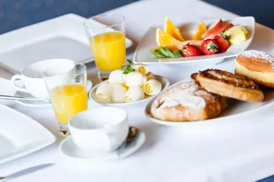 a table with plates of breakfast foods and glasses of orange juice at Gasthof Tuscherhof in Braies