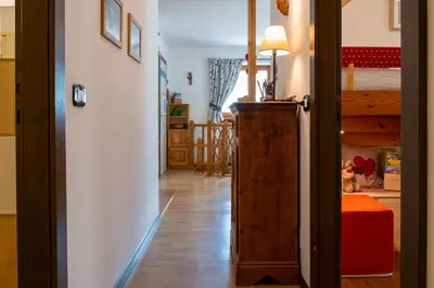 a hallway with a bedroom and a bunk bed at Cesa Leo in Canazei