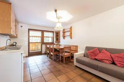 a kitchen and a living room with a couch and a table at Cesa Testa in Canazei
