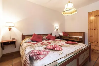 a bedroom with a bed with red pillows on it at Cesa Testa in Canazei