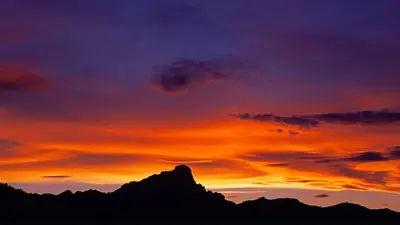 a silhouette of a mountain with a sunset at Ciasa Mirio' in La Valle