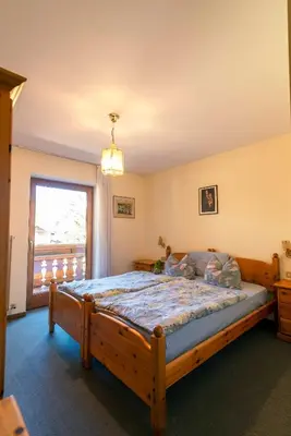 a bedroom with a wooden bed with a window at Appartamenti Césa Col De Pin in Canazei