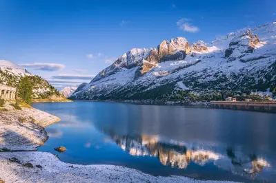 a view of a lake with snow covered mountains at Appartamenti Césa Col De Pin in Canazei