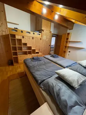 a bedroom with two beds in a room with stairs at Apartman Anda in Cavalese