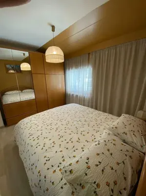 a bedroom with a bed with a white comforter at Ciamorc Relax & Sport Appartament for max 2 Adults 1 child 1 infant in Canazei