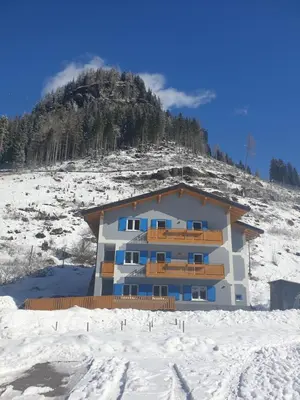 a building in the snow in front of a mountain at Ciamorc Relax & Sport Appartament for max 2 Adults 1 child 1 infant in Canazei