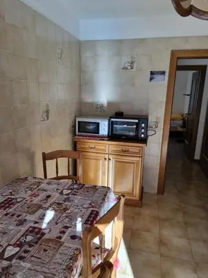 a kitchen with a table and a microwave on a counter at Ciamorc Relax & Sport Appartament for max 2 Adults 1 child 1 infant in Canazei