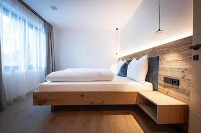 a bedroom with a bed with a wooden headboard at MANARES - my mountain stay in San Lorenzo di Sebato
