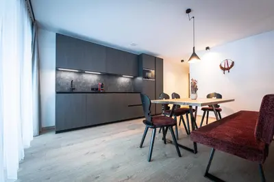 a kitchen and dining room with a table and chairs at MANARES - my mountain stay in San Lorenzo di Sebato