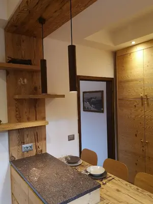 a kitchen with a counter and a table with chairs at Casalta by Go New Location in Moena