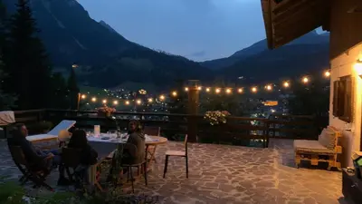 a group of people sitting at a table on a patio at Casalta by Go New Location in Moena