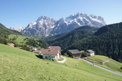 a village on a hill with mountains in the background at Miribunghof in La Valle