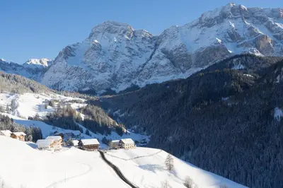 a snow covered mountain with a house in the foreground at Miribunghof in La Valle