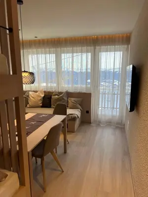 a living room with a table and a couch at Kronplatz Mountain Lodge in Brunico