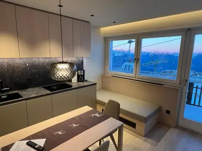 a kitchen with a dining table and a window at Kronplatz Mountain Lodge in Brunico