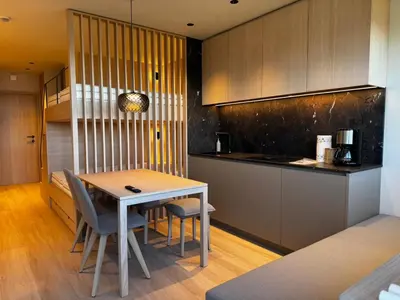 a kitchen with a table and chairs in a room at Kronplatz Mountain Lodge in Brunico