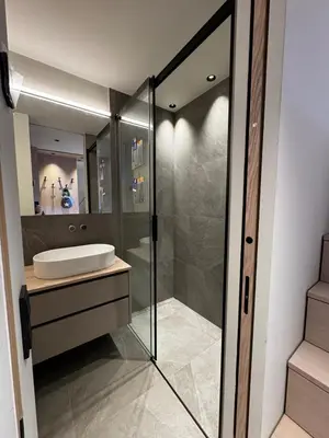 a bathroom with a glass shower and a sink at Kronplatz Mountain Lodge in Brunico