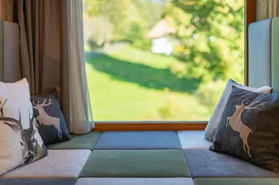 a couch with pillows sitting in front of a window at Plattner-Hof in Petersberg