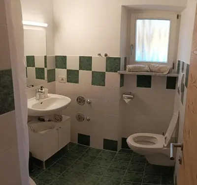 a bathroom with a sink and a toilet and a window at Rasterhof in Aldino