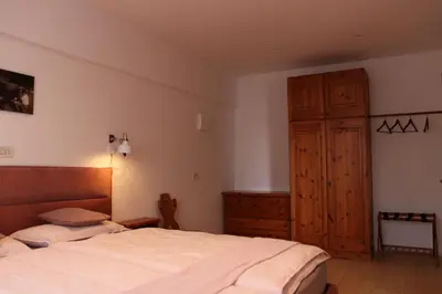 a bedroom with a bed and a wooden cabinet at Rasterhof in Aldino