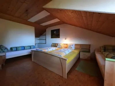 two beds in a room with wooden ceilings at Wiesenheimhof - Apt 1 in Terento