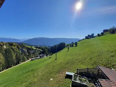 a view of a green hill with a house at Wiesenheimhof - Apt 1 in Terento