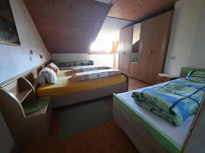 a small bedroom with two beds and a chair at Wiesenheimhof - Apt 1 in Terento