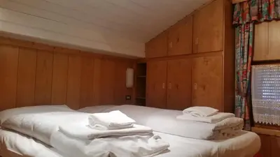 a bedroom with two beds with white towels on them at Chalet Belvedere in Arabba