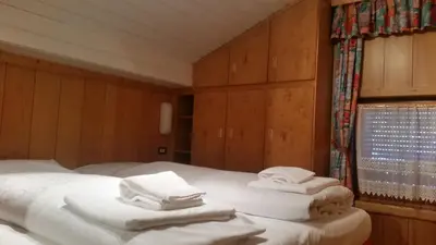 a bedroom with two beds with towels on them at Chalet Belvedere in Arabba