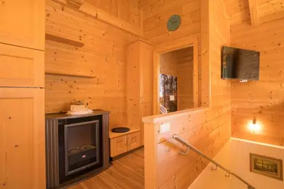 a log cabin with a fireplace and a tv at Chalet Leitn-Anger in San Leonardo in Passiria