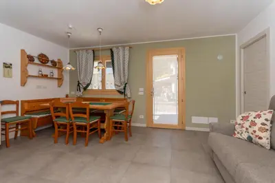 a kitchen and dining room with a table and chairs at Casa Carducci in Alleghe