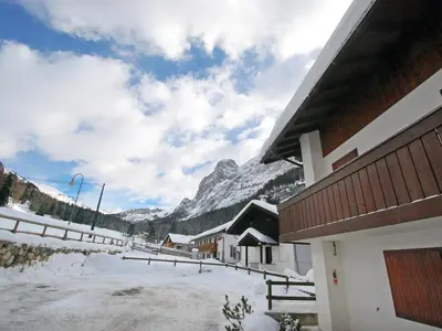 a small village in the mountains with a grass field at Apartment Penia 2-1 by Interhome in Penia