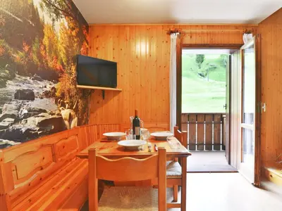 a dining room with a wooden table and a tv at Apartment Penia 2-1 by Interhome in Penia