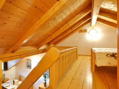 an attic room with wooden ceilings and a staircase at Apartment Villa Placidia Apt 32 by Interhome in Campitello di Fassa