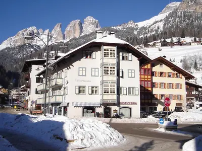 a large white building in front of a mountain at Apartment Villa Placidia Apt 32 by Interhome in Campitello di Fassa