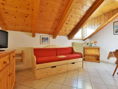 a living room with a red couch and a tv at Apartment Villa Placidia Apt 32 by Interhome in Campitello di Fassa