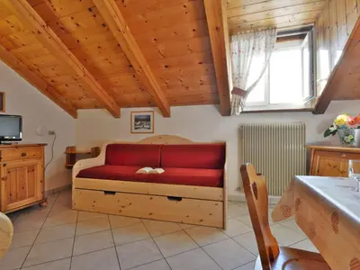 a living room with a red couch and a window at Apartment Villa Placidia Apt 32 by Interhome in Campitello di Fassa