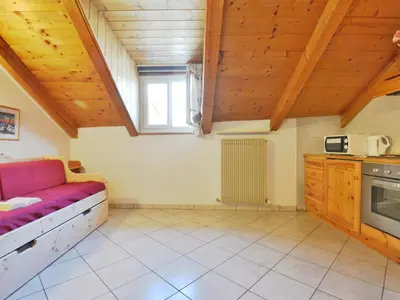 a large room with a couch and a window at Apartment Villa Placidia Apt 34 by Interhome in Campitello di Fassa