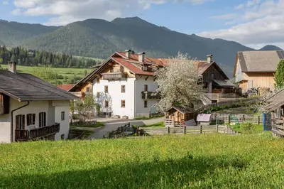 a village with houses and mountains in the background at Schusterhof - Urlaub auf dem Bauernhof in Novale