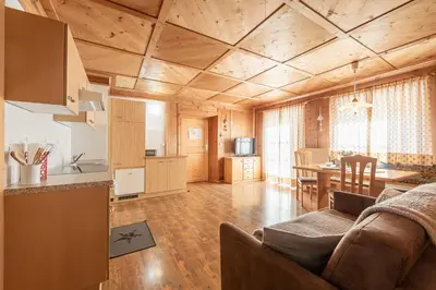 a living room with a couch and a dining room at Schusterhof - Urlaub auf dem Bauernhof in Novale