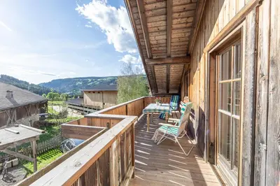 a wooden balcony with a table and chairs on it at Schusterhof - Urlaub auf dem Bauernhof in Novale