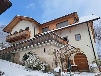 a house with a balcony on top of it at Pignathof Rosacea in Campodazzo