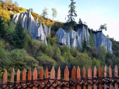 a fence in front of a mountain with rocks at Wiesenheimhof - Apt 2 in Terento