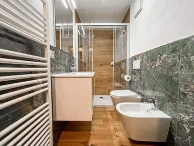 a bathroom with a sink and a toilet and a shower at Appartamenti Des Alpes in Canazei